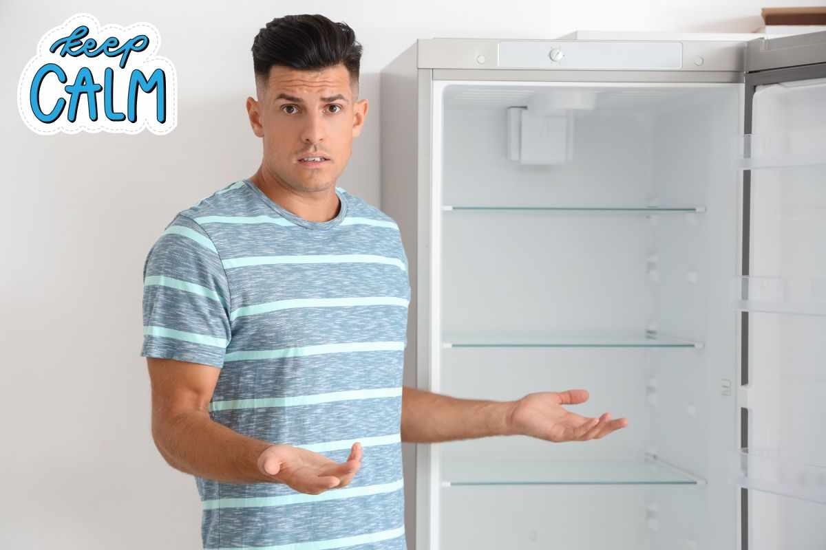 Uomo davanti a frigo vuoto