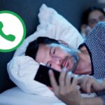 uomo con telefono in mano e logo whatsapp